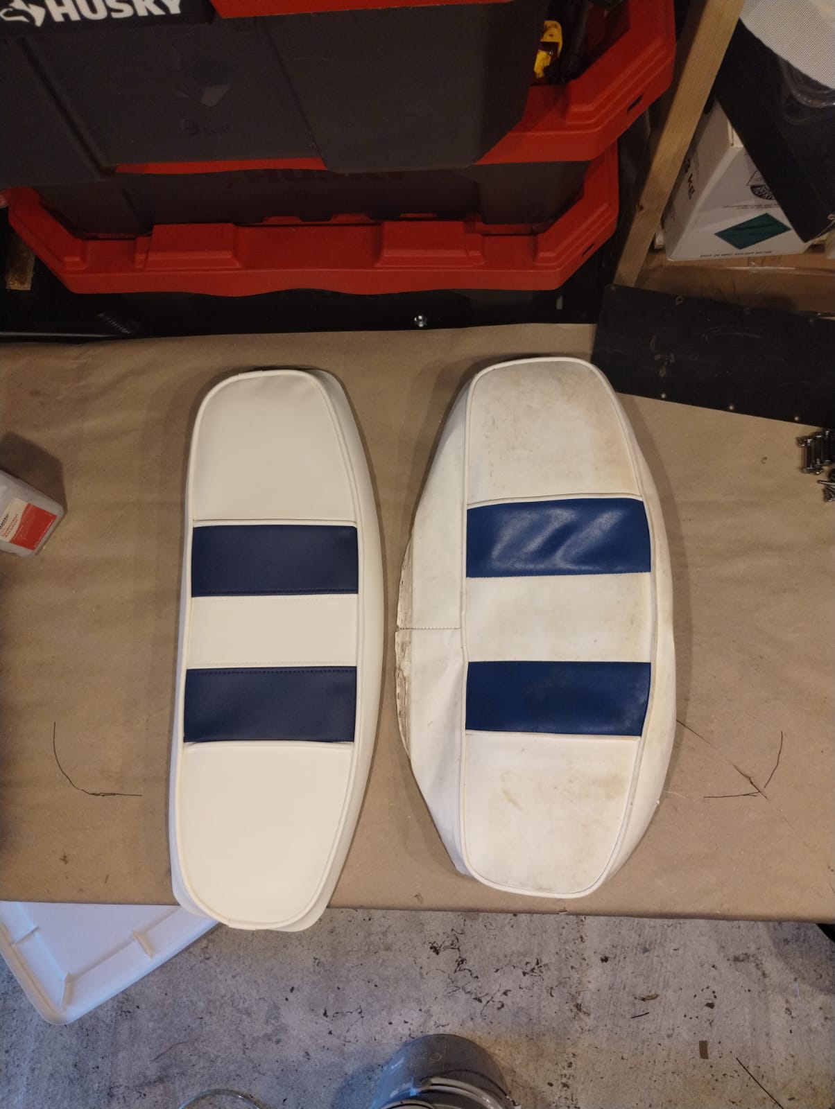 New white and navy boat bolster cushion next to old worn bolster cushion