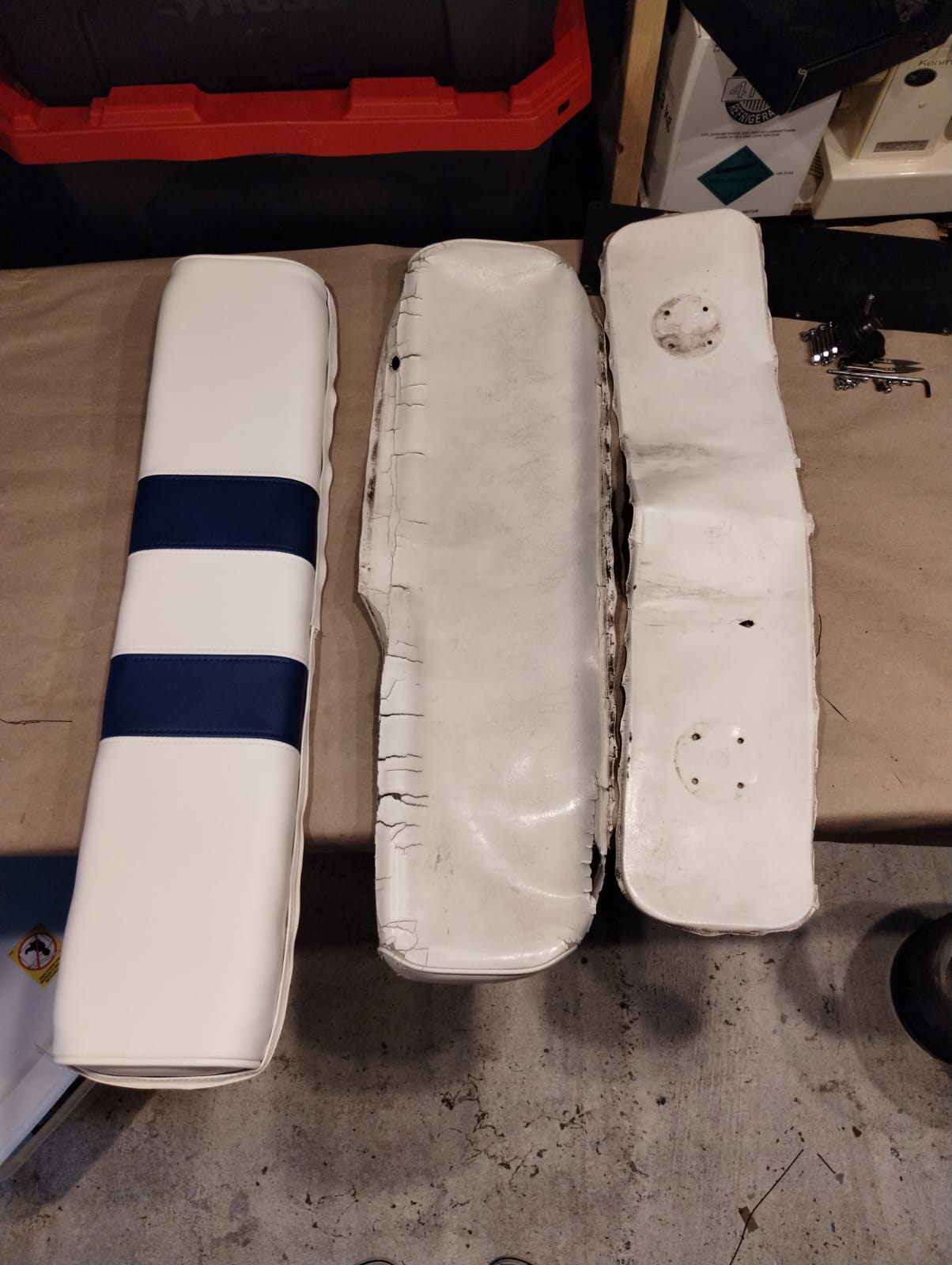 Side-by-side comparison of new marine vinyl boat cushion and worn original cushions before reupholstery