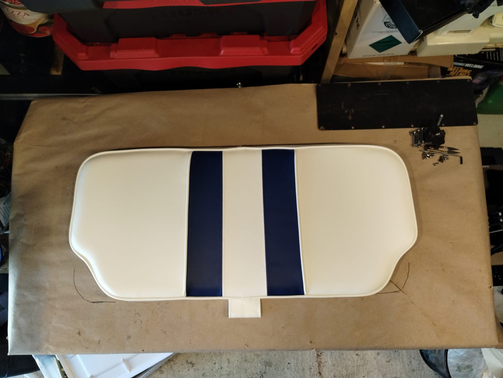 Top-down view of finished boat bench seat cushion in white marine vinyl with navy stripes