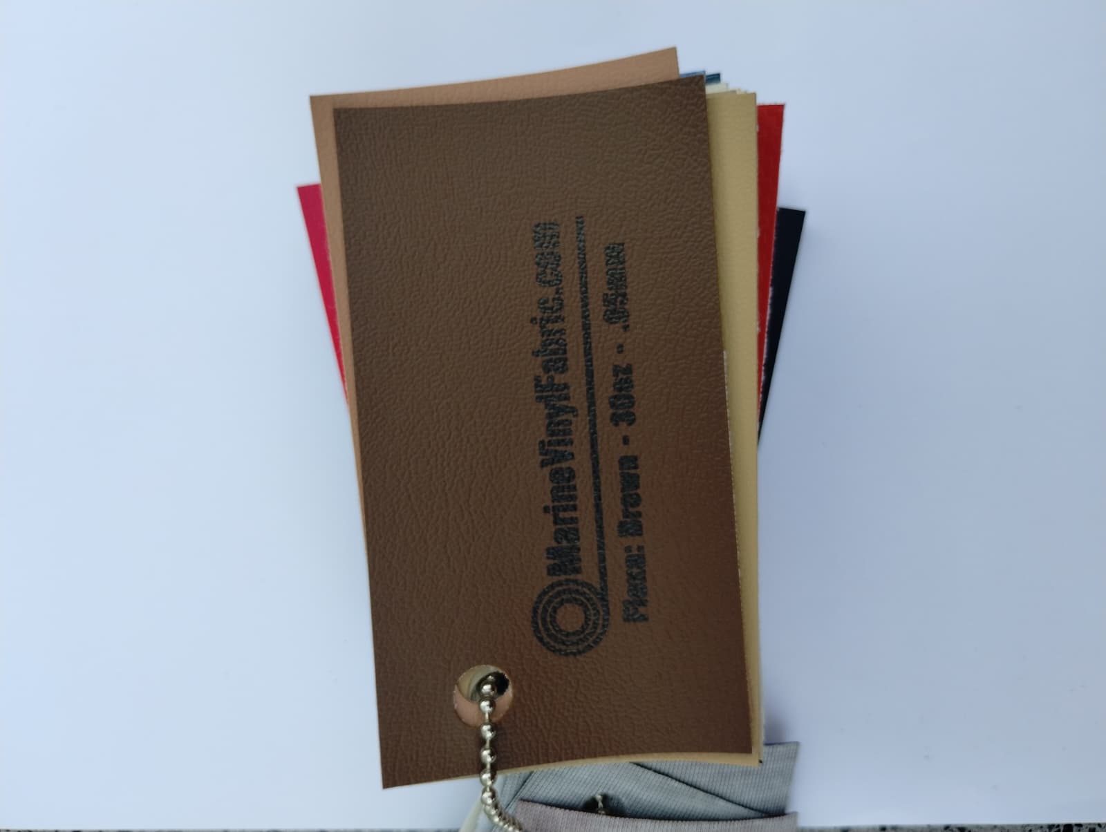 Brown Flexa marine vinyl upholstery fabric swatch on a sample ring, 30oz and 0.95mm marine grade