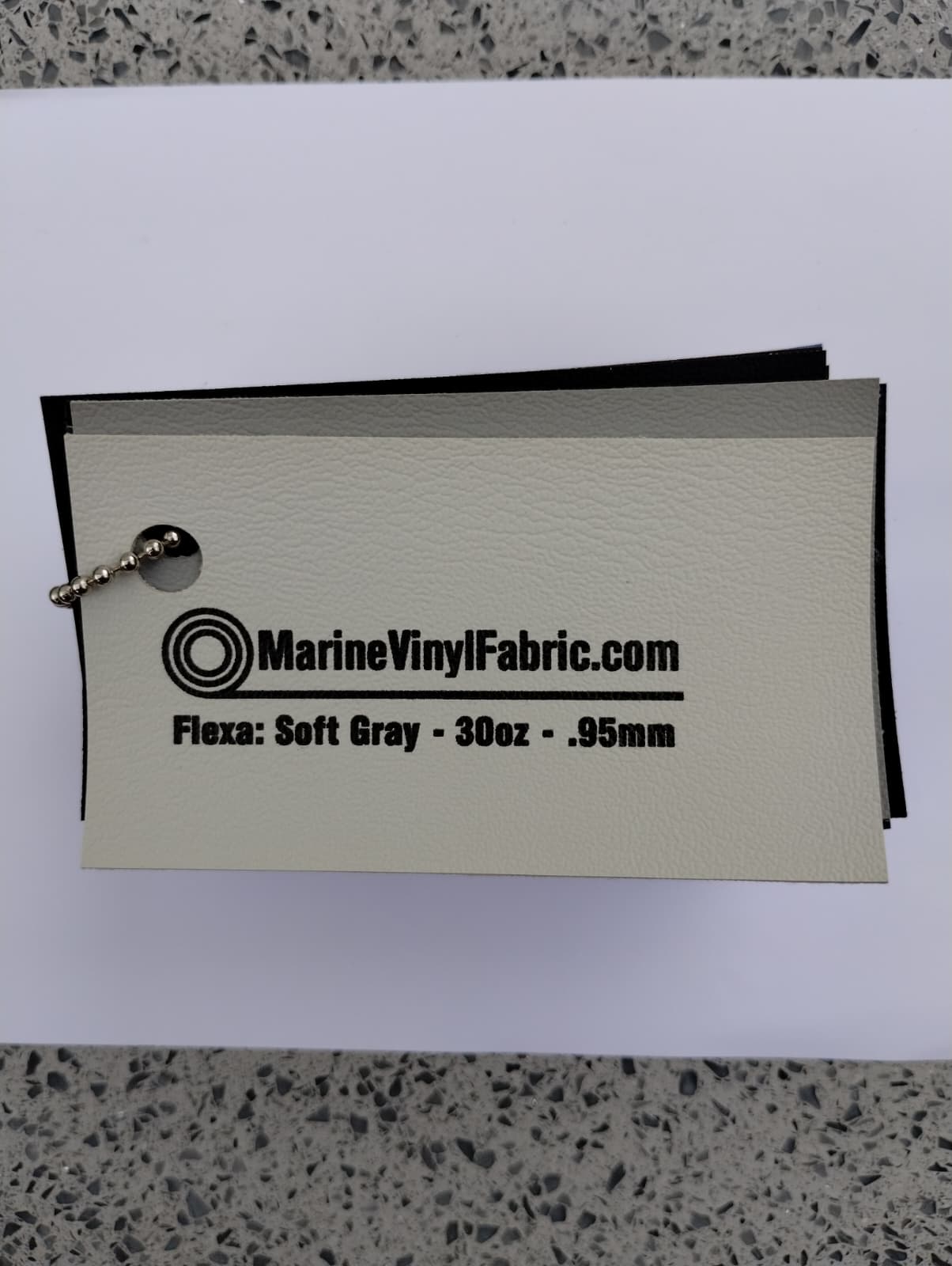 Soft gray Flexa marine vinyl upholstery fabric swatch on a sample ring, 30oz and 0.95mm marine grade