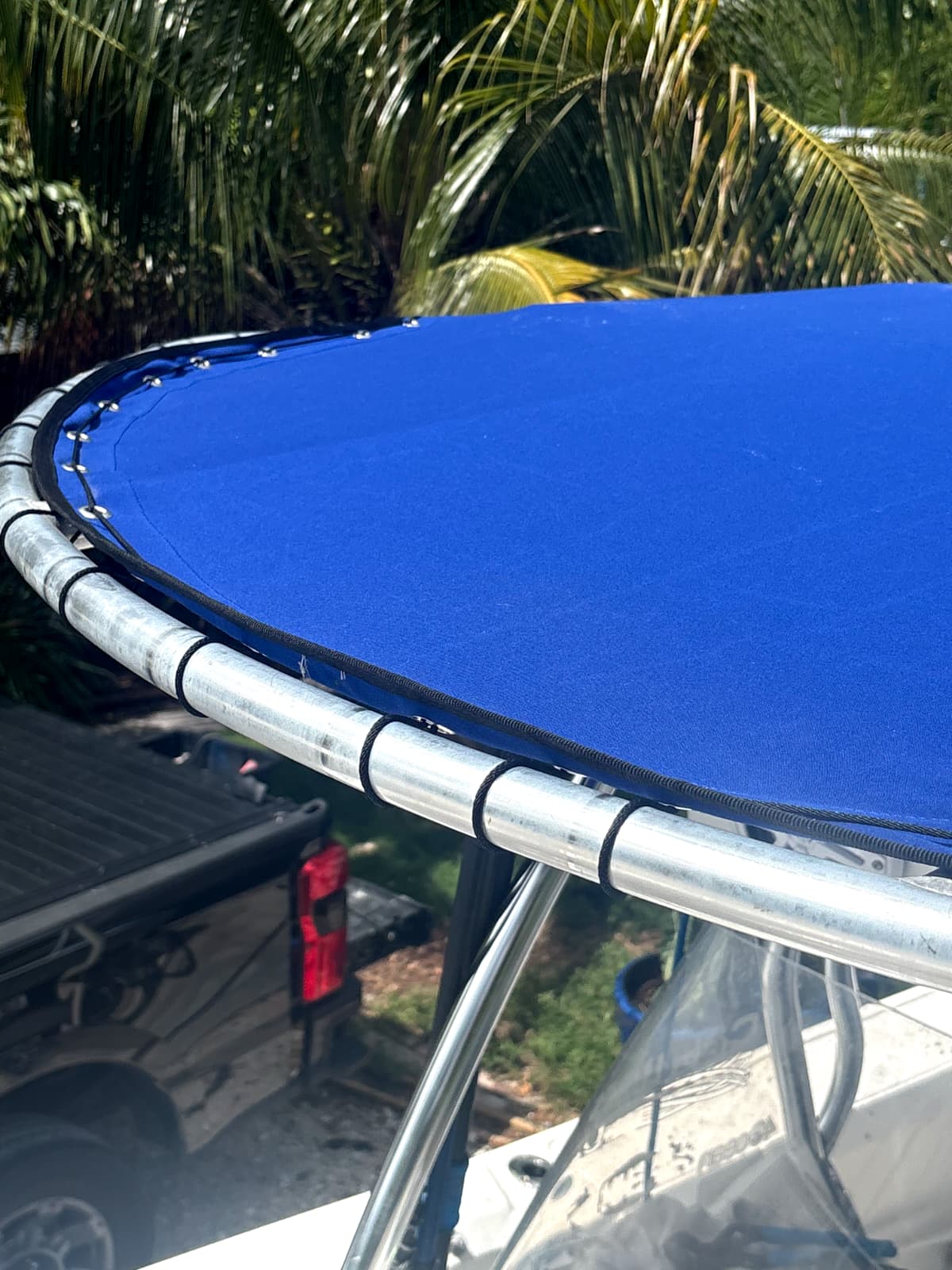Close-up of new blue boat T-top canvas laced tight to the aluminum frame with grommets and bound edge