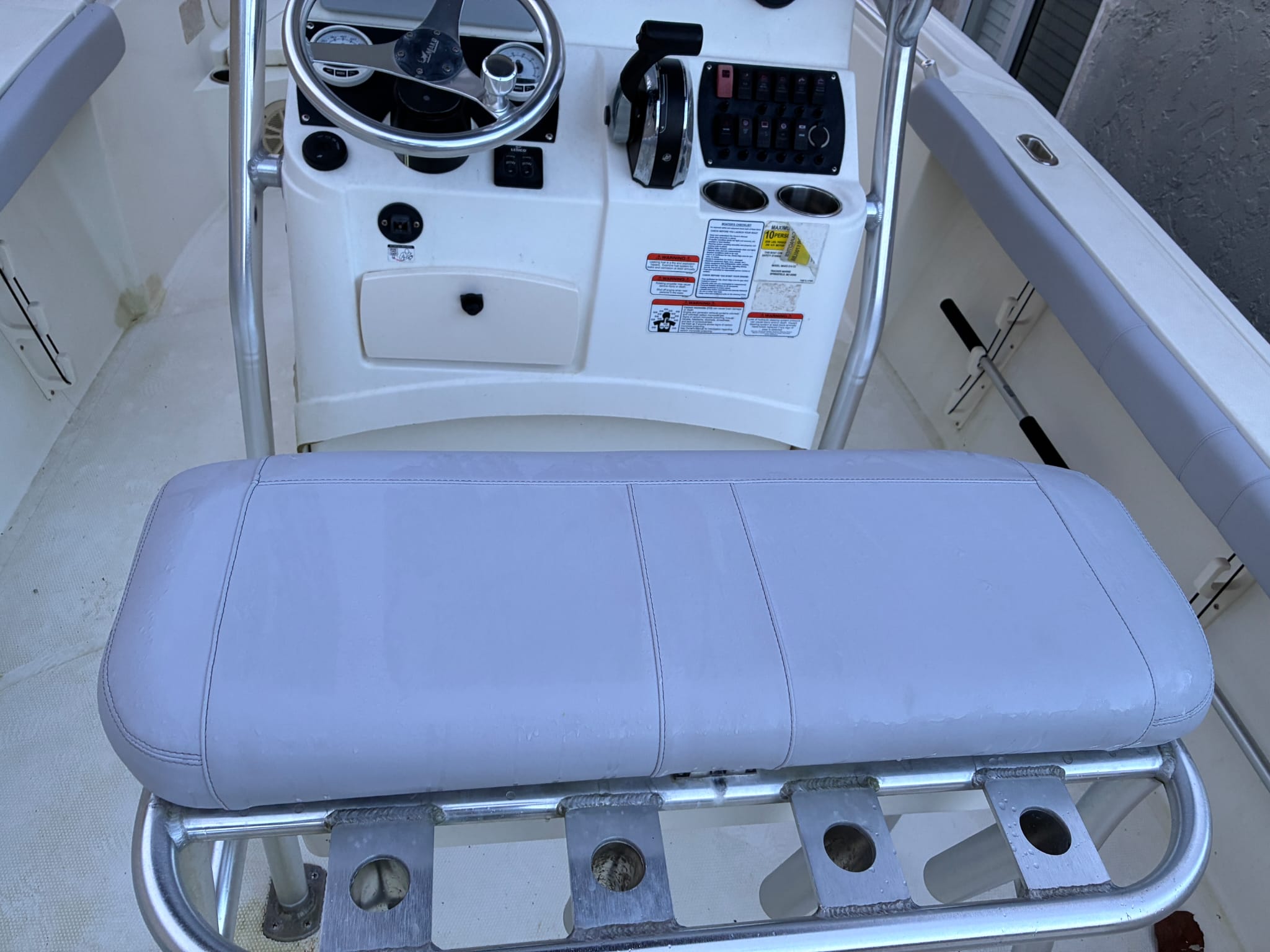 Top-down view of a freshly reupholstered boat leaning post seat cushion.